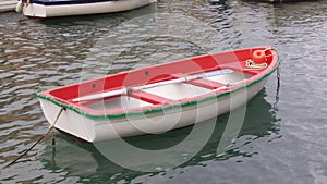 A small red rowing boat in the bay of portofino