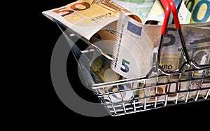 Small red shopping basket full of euro banknotes. Finance. Financial crisis. Banking system. Economic problem. Inflation.