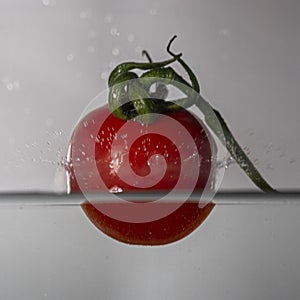 small red tomato drop in water with a splash