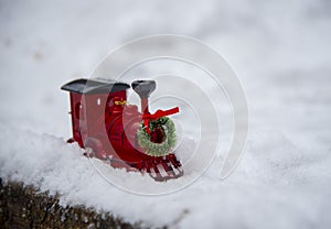 A small toy train stands in the fluffy snow