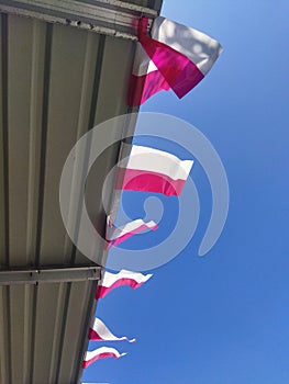 Small red and white flags against a blue sky background. Indonesian independence day celebration.