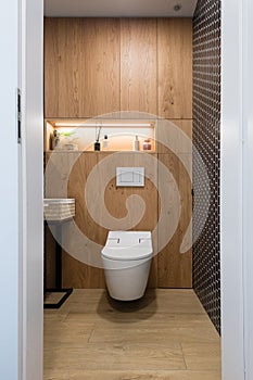 Small restroom with wooden pannels on the wall