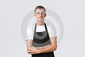 Small retail business owners, cafe and restaurant employees concept. Handsome barista, salesman in glasses and black