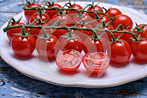 Small ripe red sweet cherry tomatoes on twig