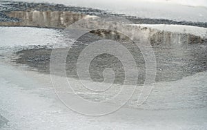 Small river or creek covered with ice in winter, snow crystals visible
