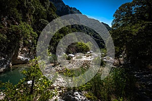 Small river enveloped with rocks. Closeup of river scenes in forest in Epirus Greece