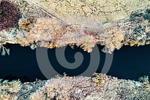 Small river by field, meadows and wood of the bird`s-eye view in winter