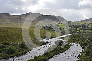 Small River Flow in Green Vegetation and Mountain Landscape in a National Road in Ireland