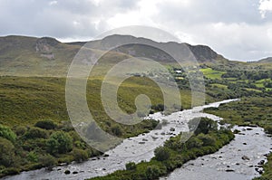 Small River Flow in Green Vegetation and Mountain Landscape in a National Road in Ireland