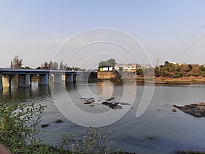 A small river going under the bridge in a village