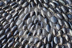 Small river rocks set in concrete in a abstract pattern, as graphic background