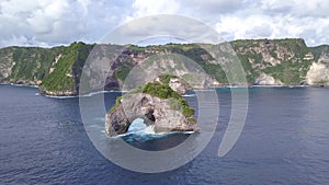 Small Rock Arch Island in the Sea. Nusa Penida, Indonesia. 4K Aerial View.