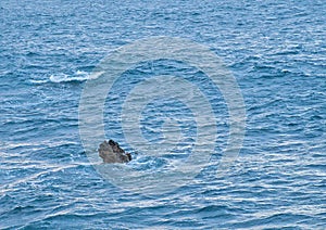 small rock near the coast of the blue atlantic ocean
