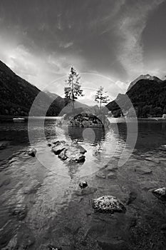 Small rocky island with tree on lake Hintersee nea photo