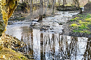 a small rocky river in a rural area in early spring