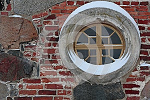 A small round and decorative window of an ancient church