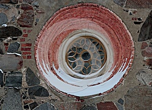 A small round and decorative window of an ancient church