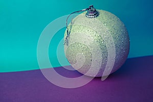 Small round glass plastic beautiful xmas festive Christmas ball, Christmas toy plastered over sparkles on a blue background