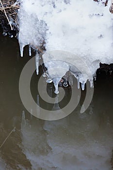 Small round icicles over water