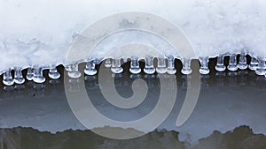 Small round icicles over water