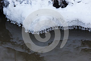 Small round icicles over water