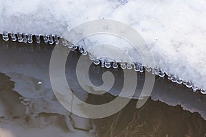 Small round icicles over water