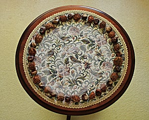 On a small round table there is a drawing of dried chestnut fruits