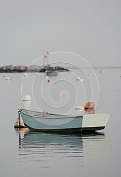 A small rowboat floats in the harbor