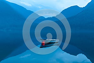 small rowing boat reflects in the water