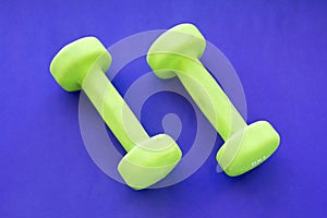 Small rubberized dumbbells 1 kg on a purple background