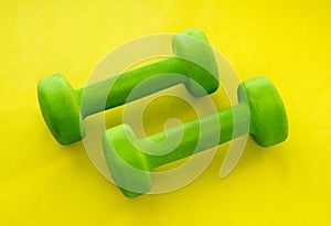 Small rubberized dumbbells 1 kg on a yellow background