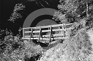 A small rudimentary wooden bridge in the Swiss alps, shot with analogue film technique photo