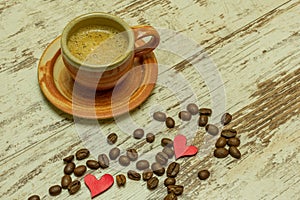 A small rustic coffee mug stands on an old wooden