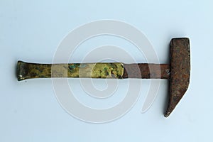 A small rusty iron hammer with a slightly grubby yellow handle