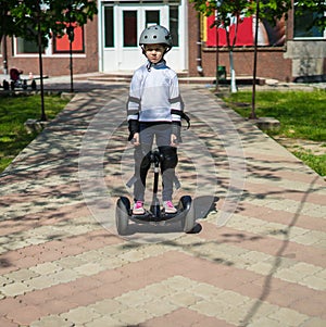 Small sad girl riding electric mini hoverboard