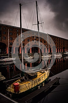 a small sailboat docked in front of an industrial building