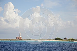 A small sailboat is floating in the ocean near a lighthouse remote loneliness cloudy photo