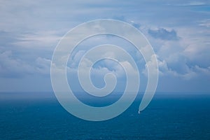 Small Sailboat on the Ocean under a Cloudy Sky