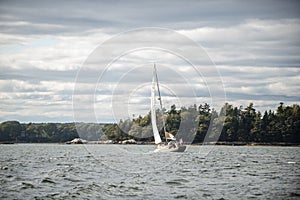 Small sailboat on the open water in Casco Bay in Maine in the fall