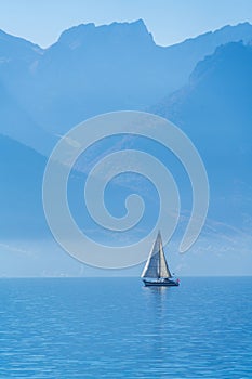 A small sailing yacht on the Lake Geneva and the Alps, Switzerland