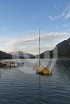 Small sailing yacht at sunset on Alpine lake Mondsee, Austria