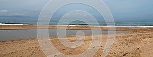 Small sandbar where the Pacific ocean and the Santa Clara river meet at Surfers Knoll beach in Ventura California USA