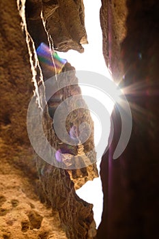 A small sandstone cave divided by huge cracks and illuminated by the sun. Close up sandstone texture background, natural surface