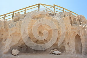 Small sandstone caves with wooden walkway, Cala Conta, Ibiza.