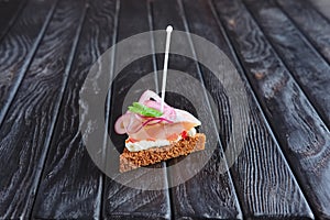 Small sandwich with herrings,cheese and onion on skewer