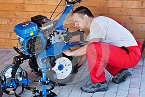 Small scale agriculture - man checking on small motorized tiller photo