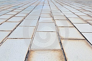Small-scale background texture of old white tile pavement