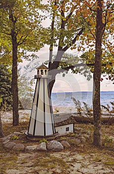 Small scale wood lighthouse sits on shore of Traverse Bay in Michigan. This is a fall season photo from Lake Michigan area.
