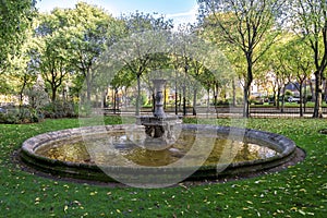 A small scenic antique fountain in the park near the Army Museum at Les Invalides complex, Paris