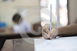 Small school boy writing homework from school in workboo photo